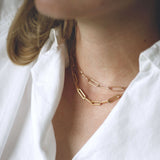 woman wearing two gold paper clip chain necklaces